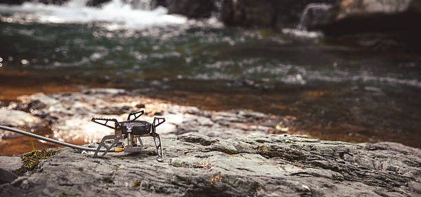 Cooking food using camping gas during the hike. River. Carpathians