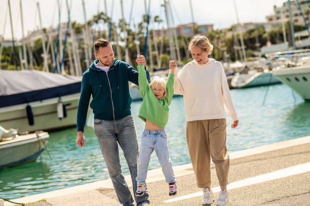 istock Family walking along marina pier together talking 2230955953