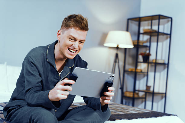 istock Joyful young man playing video game in cozy bedroom evening 2230956527