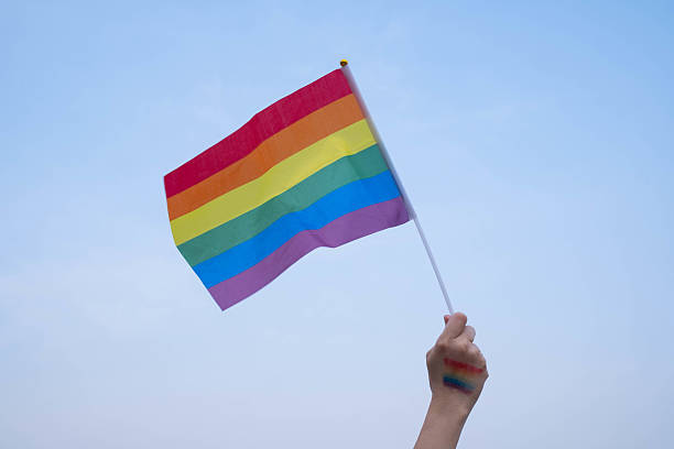 istock A vibrant rainbow flag held high against a clear blue sky, symbolizing pride, diversity, and inclusion in the LGBTQ+ community and beyond. 2230958183