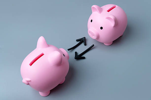 istock Two piggy banks and arrows symbolizing an exchange or transfer. 2230958492