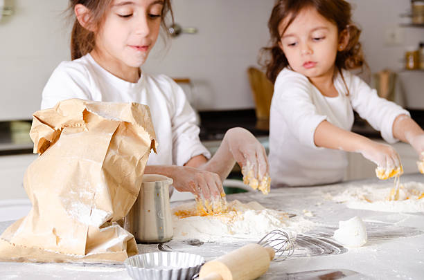 istock Two little sisters cooking at home. 2230959228