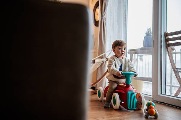 istock Cute Baby Boy Playing on Toy Car 2230960308