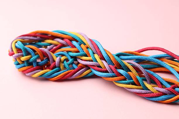 istock Colorful ropes tied together on pink background, closeup. Unity concept 2230962098