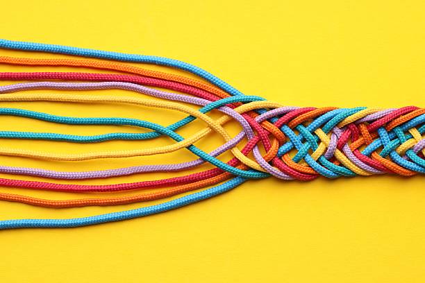 istock Colorful ropes tied together on yellow background, top view. Unity concept 2230962126