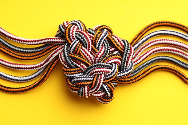 istock Colorful ropes tied in knot on yellow background, top view. Unity concept 2230962134