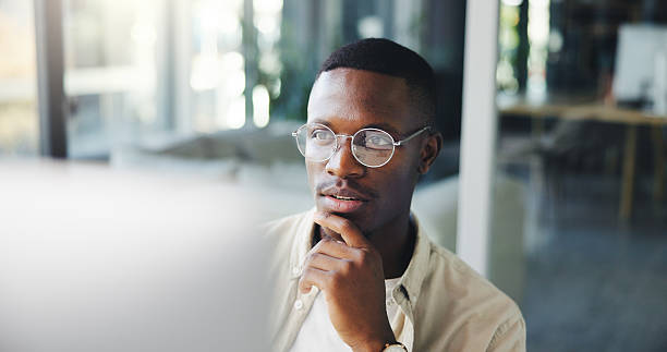 istock Thinking, reading and business man on computer for decision, insight or journalist planning. African worker, idea and creative brainstorming, problem solving or inspiration for news story in office 2230962361
