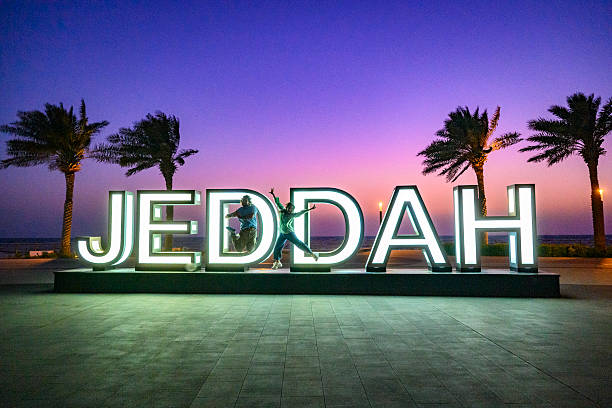 istock Two young people jumping at Jeddah sign at sunset 2230962711