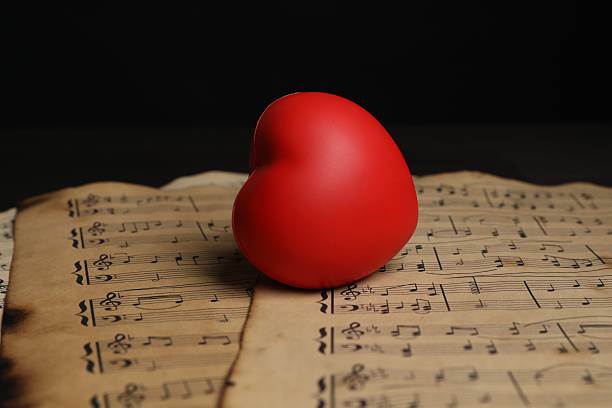 Heart figure and musical notes on black background, closeup