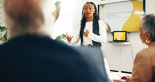 istock Business people, presentation and woman in office, feedback and planning with development. Workshop, collaboration or group in meeting, speaker or seminar for information, negotiation or conversation 2230965263