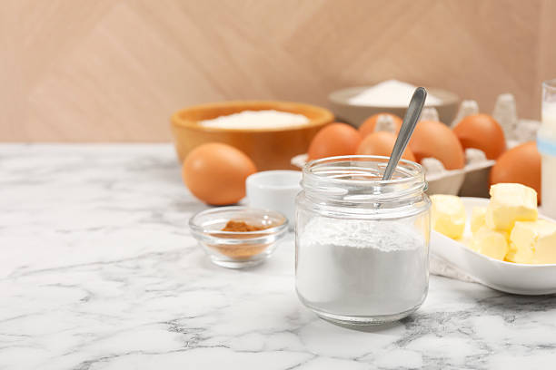 istock Baking powder in jar and other products on white marble table, closeup. Space for text 2230965388