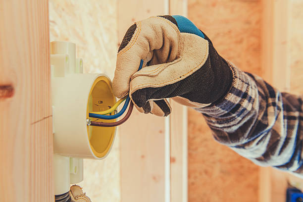 istock Electrician Connects Wires in a Junction Box Inside a New Construction Site 2230966576