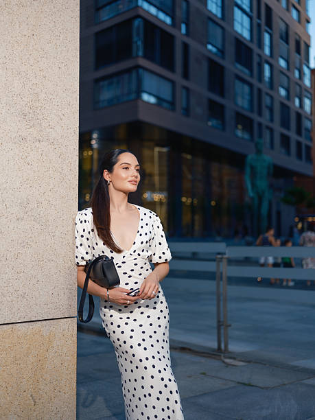 Stylish Woman Leaning on Pillar in urban setting