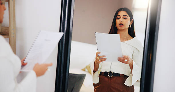 istock Practice, speech and woman in mirror in home for public speaking, presentation and monologue. Talking, reflection and person with paperwork, documents and reading for oral, proposal and lecture 2230968896
