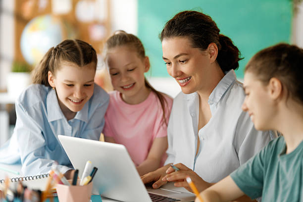 istock Happy kids and teacher at school 2230969730
