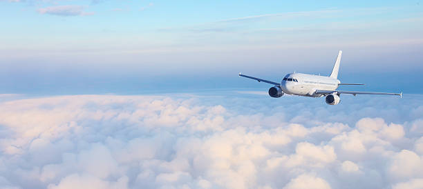 istock White passenger airplane flying above clouds at sunrise 2230970285