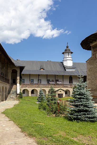 istock inner courtyard of a romanian orthodox monastery, featuring historic architecture, green grass, young evergreen trees 2230971297