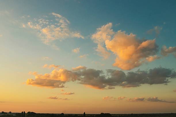 Dark clouds in the light of the setting sun, evening light in the sky, blue clouds with evening sunlight against the dark sky.