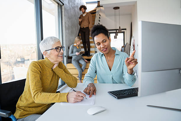 istock Mentorship and diversity in a modern office as colleagues share a laptop for team collaboration 2230974310