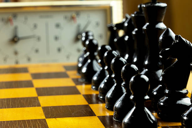 istock A close-up of a chessboard with black pieces arranged in a row. 2230976303