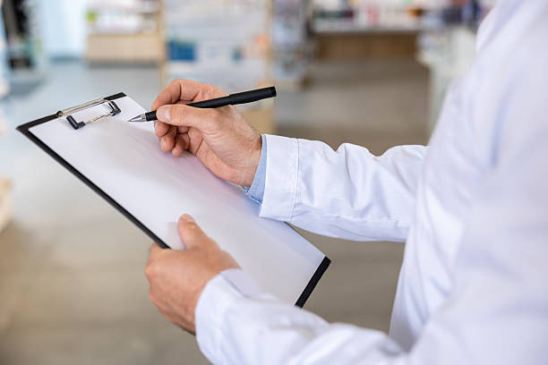 istock Close up picture of a man in lab coat making notes 2230977436