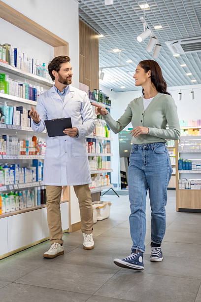 istock Pharmacy assistant with a notepad in hands talking to a female client 2230977441