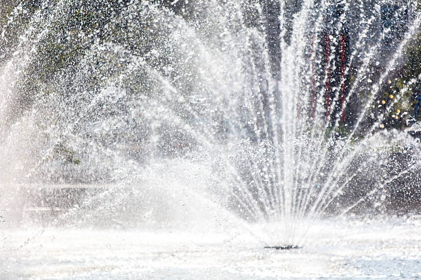 Vertical water jet from public fountain during day of summer with sunlight in Trois-Rivières, Québec, Canada