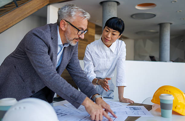 istock Architects reviewing blueprints in modern office 2230980955