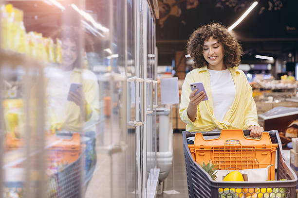istock Woman Using Smartphone While Shopping in Supermarket 2230981729