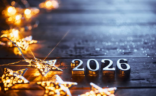 istock Silver 2026 Numbers Framed by Glowing Stars on a Dark Wooden Surface 2230983196