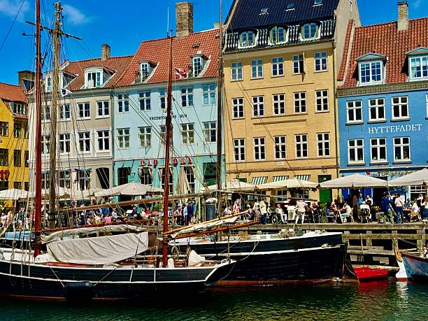 Nyhavn ia a 17th-century waterfront, canal and entertainment district in Copenhagen, Denmark.The colorful houses of Nyhavn are one of the most iconic sports  with restraints along the canal.