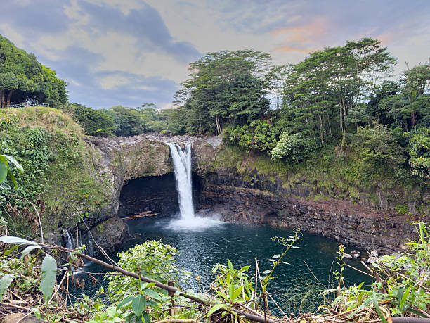istock Scenic Waterfall in Lush Greenery Under Pastel Sky 2230990711