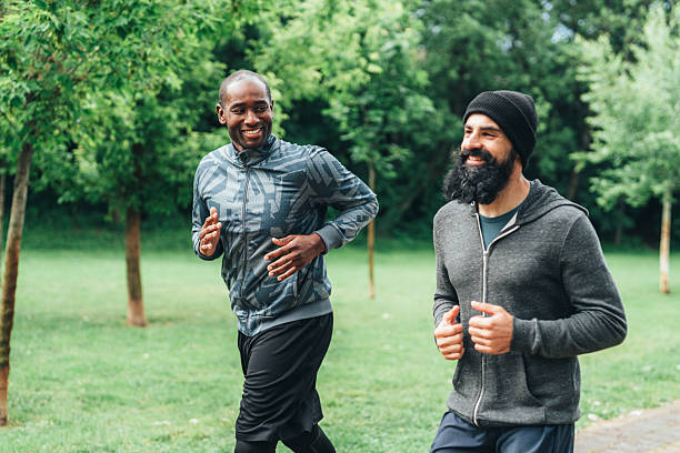 istock Cardio training outdoors. Happy athletes having fun while running together in nature. 2230996826