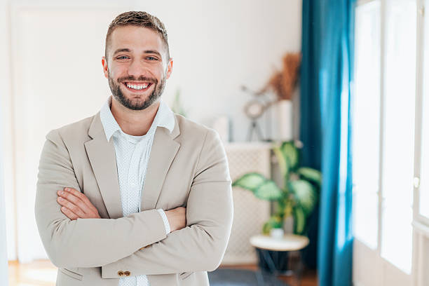 istock Successful businessman smiling with arms crossed in modern office 2231004335