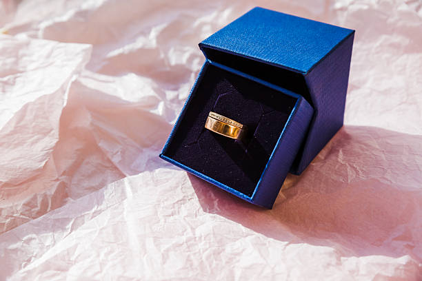 istock Engagement ring in blue gift box on pink background. Romantic gift idea. wedding ring artistically placed to encircle part of a wedding invitation on a soft background. Gold ring special gift 2231006767