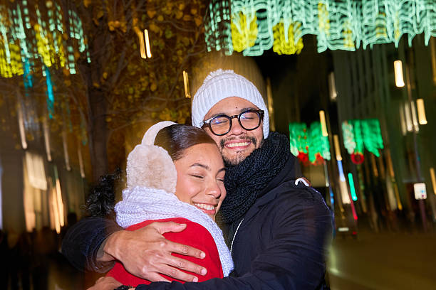 istock Happy couple embracing under christmas lights at night 2231006895