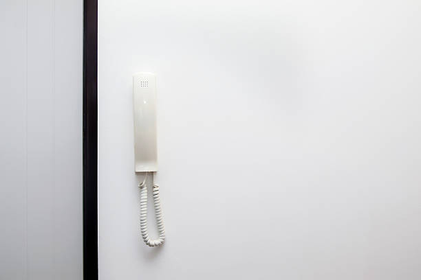 A clean, modern white phone or intercom with a detached telephone receiver. This mock up image has generous copy space and is perfect for communicating in a contemporary setting.