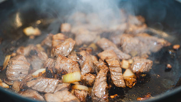 istock Cubed Beef Sizzling in Pan with Onions and Garlic 2231018449