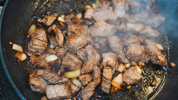 istock Cubed Beef Sizzling in Pan with Onions and Garlic 2231018461