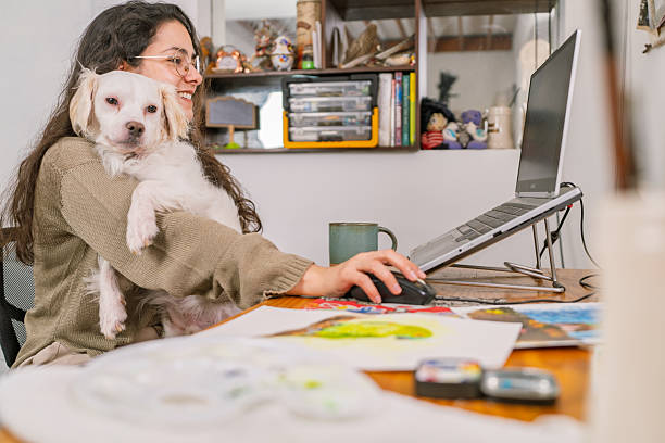 istock Graphic designer working from home with her dog 2231021329
