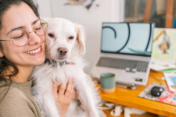 istock Graphic designer hugging her dog while working from home 2231021334