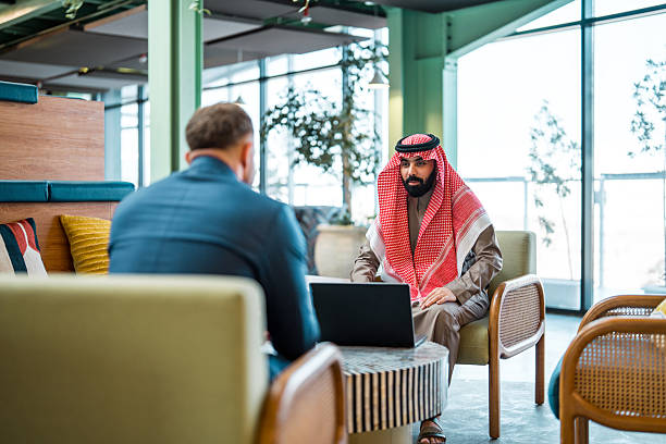 istock Middle Eastern and Caucasian Businessmen Collaborating in Modern Sunlit Coworking Space 2231023654