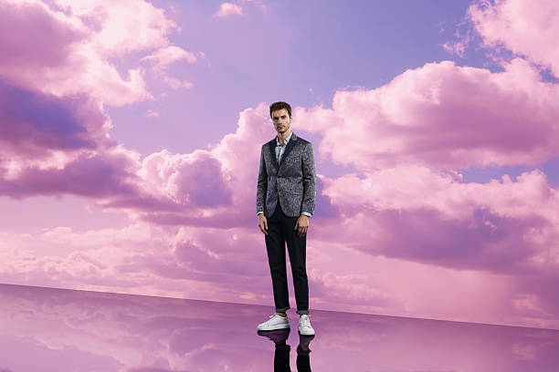 istock Elegant Man in Patterned Blazer Against Pink Sky Clouds 2231023699