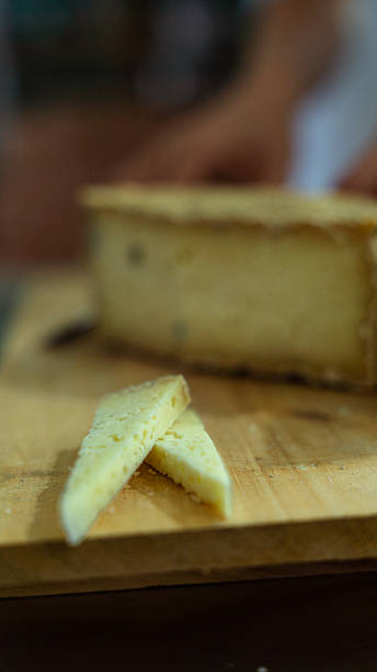 istock Cheesemaker cutting a piece of cheese in a cheese factory 2231023963
