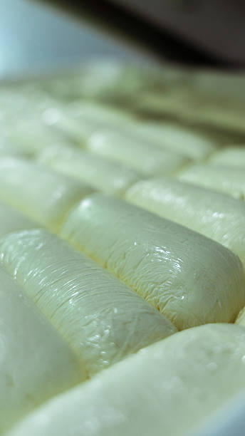 istock Fresh cheese loafs wrapped in plastic wrap lying in a cheese factory 2231023976