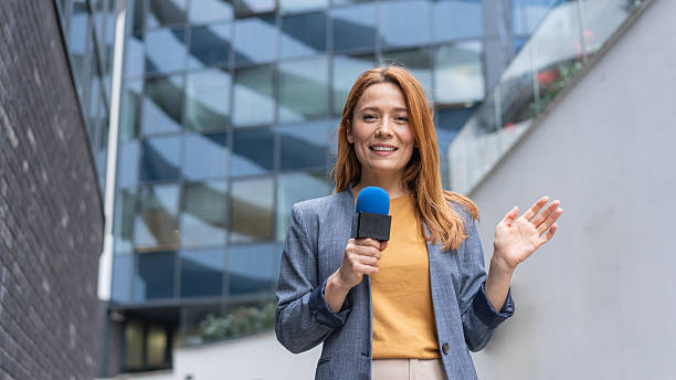 istock Dynamic female journalist with microphone ready to report 2231025226