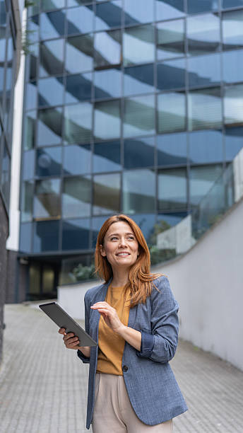 istock Smiling Businesswoman with Tablet in Contemporary Setting 2231025227