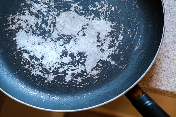 istock Old frying pan with damaged non-stick coating and scratched surface placed on kitchen countertop 2231026870