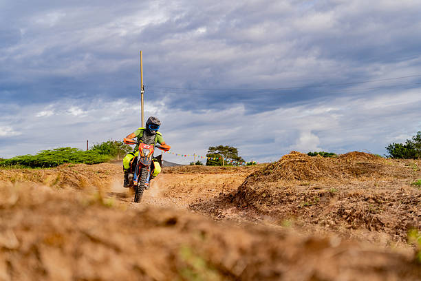 A young dirt bike rider tearing through the woods on his motorcycle scrambler.