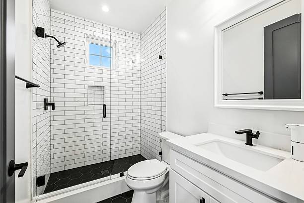 istock Modern white bathroom with subway tiles and black fixtures. 2231033996